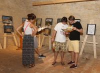 Návštěvníci výstavy si se zájmem prohlížejí informační materiály. Na snímku skupinka listuje v katelogu CK China Tours, která za památkami UNESCO své klienty pravidelně vozí (foto Erika Valkovičová)